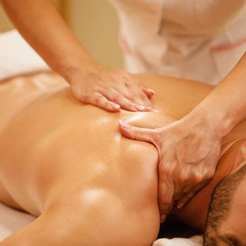Close-up of man having back massage during spa treatment at wellness center.